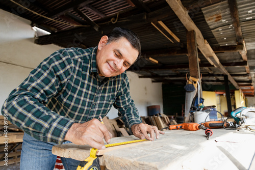 Mexican carpenter working in his workshop-Smiling mature man working in carpentry workshop-Happy carpenter working