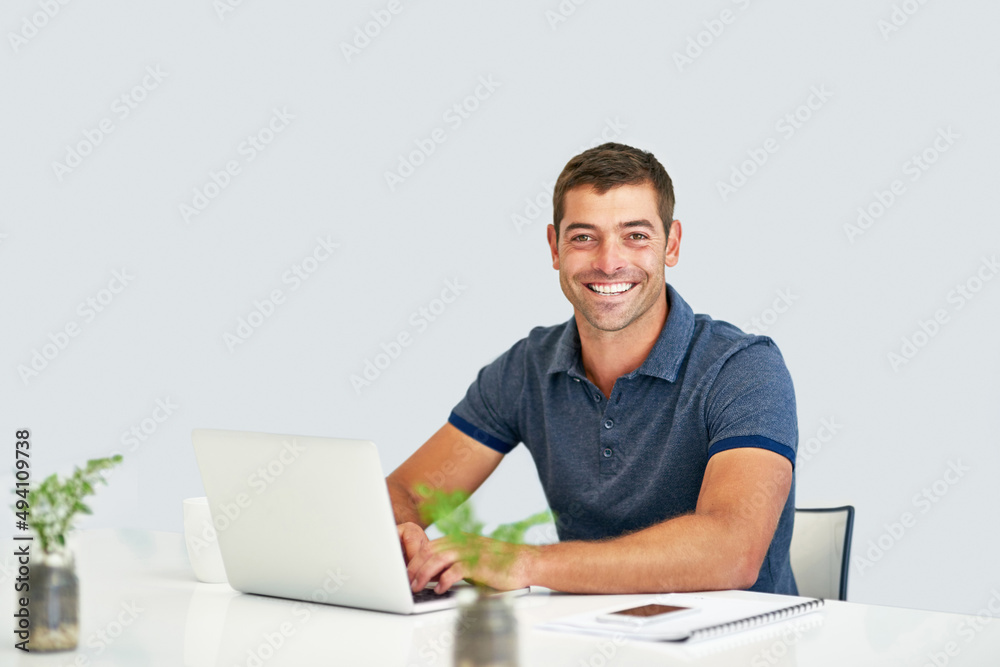Feeling accomplishment from finishing his deadlines. Portrait of a young man working on a laptop against a white background. Feeling accomplishment from finishing his deadlines. Portrait of a young man working on a laptop against a white background.