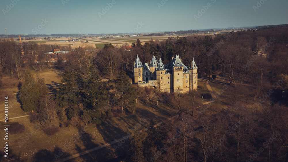 Old castle with a beautiful park in Goluchow, Poland. An aerial view drone photo in neutral colors.