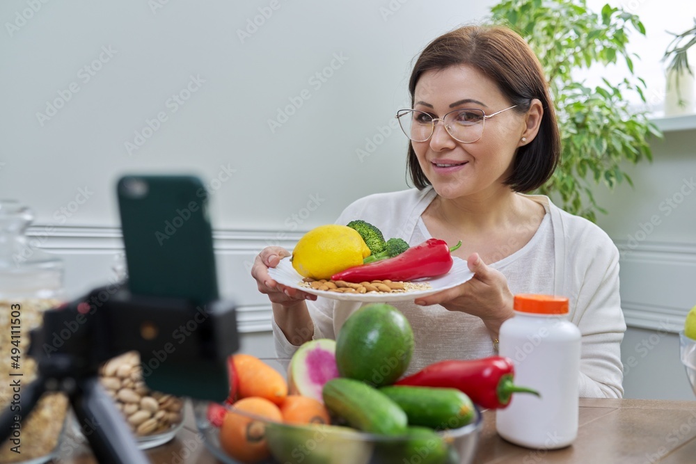 Woman recording video stream about healthy eating, vitamins, nutritional supplements Woman recording video stream about healthy eating, vitamins, nutritional supplements