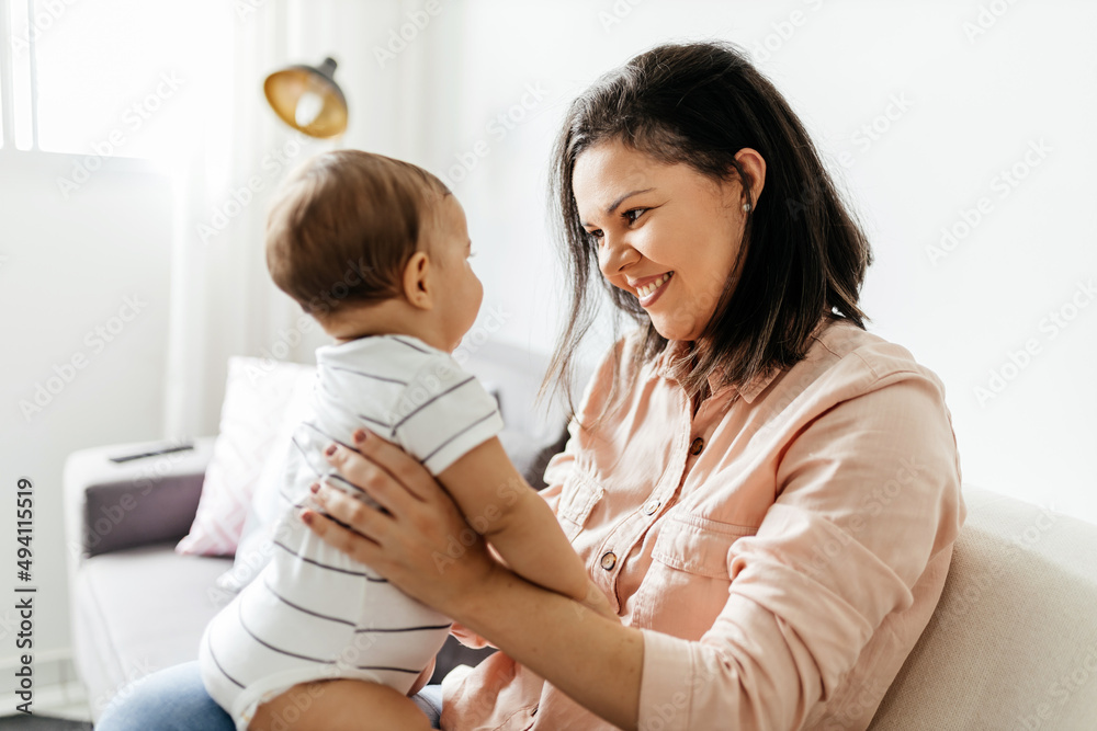 Mother and her baby son playing at home