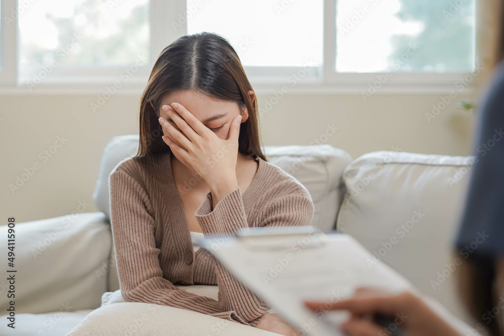 Psychology, depression. Sad, suffering asian young woman consulting with psychologist, psychiatrist while patient counseling mental with doctor woman taking notes at clinic. Encouraging, therapy. Psychology, depression. Sad, suffering asian young woman consulting with psychologist, psychiatrist while patient counseling mental with doctor woman taking notes at clinic. Encouraging, therapy.
