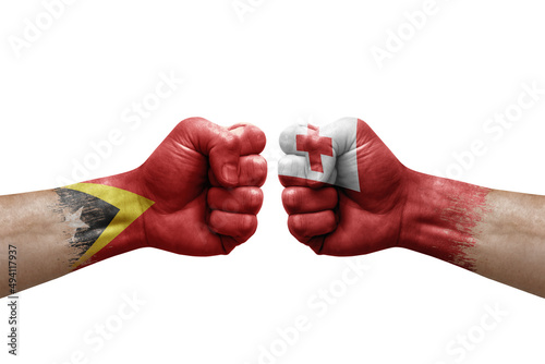 Two hands punch to each others on white background. Country flags painted fists, conflict crisis concept between timor leste and tonga