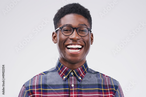 Now that IS funny. Studio portrait of a handsome young man laughing against a grey background.