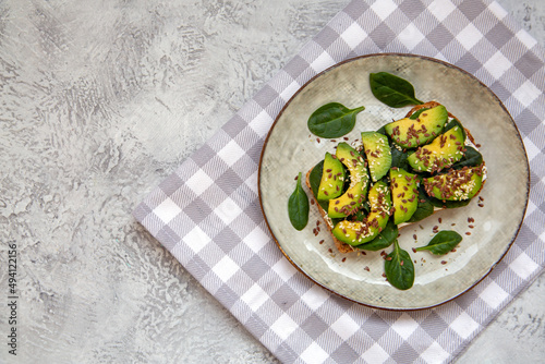 Toast with avocado, cottage cheese, spinach, sesame seeds, flax seeds. Healthy food rich in fiber, trace elements, omega acids, unsaturated lipids.