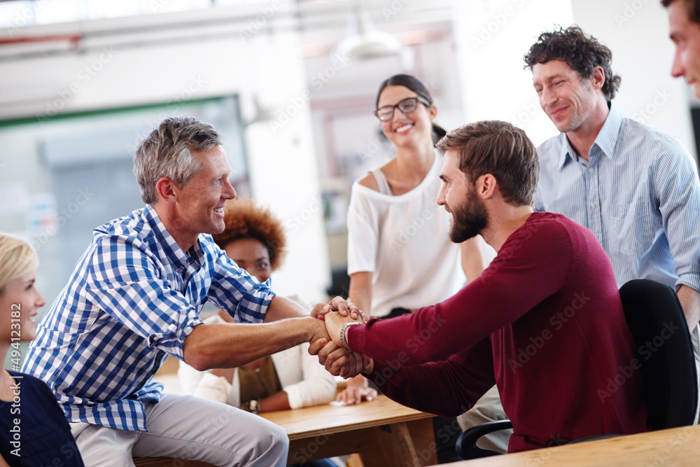 Fototapeta premium Youve been doing a great job. A mature businessman shaking hands with a colleague during an informal office meeting.