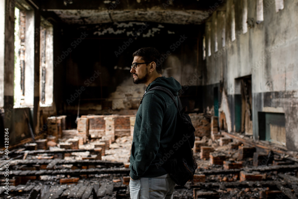 Destroyed building. Burnt building . Broken windows with ash . A man in a destroyed burnt building .