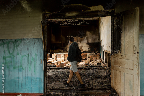 Destroyed building. Burnt building . Broken windows with ash . A man in a destroyed burnt building . © Антон Романюк