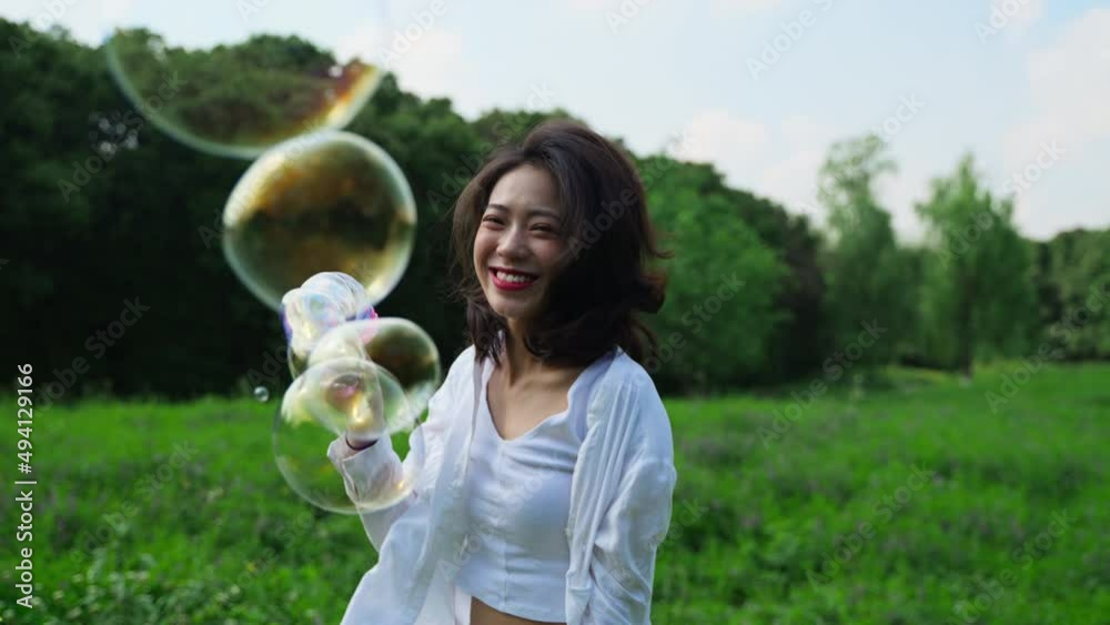 Young girl running, jumping and playing soap bubbles on grass slow motion clip Young girl running, jumping and playing soap bubbles on grass slow motion clip
