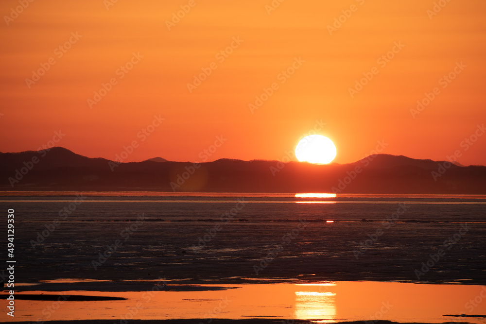 氷が浮かぶ夕暮れの光る湖
