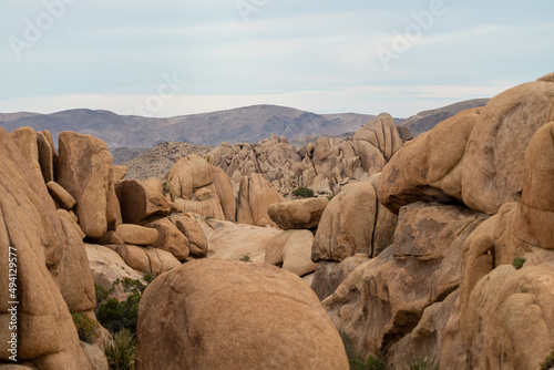 Joshua Tree National Park landscape with huge rock boulders in view for climbing. Clouds in background. 