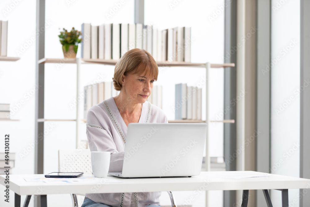 senior woman using laptop computer and serious at work senior woman using laptop computer and serious at work