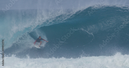 Surfer surfing big wave barrel tube