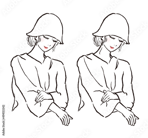サウナに入る女性。下を向いて目を閉じている。ロングヘアでサウナハットとポンチョを身につけている。