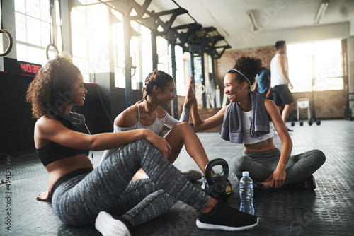 Best friends motivate you to be better. Shot of young women giving each other a high five while taking a break at the gym.