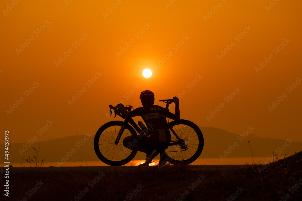 Fototapeta premium silhouette of a cyclist on sunset, the scenery sunrise in the morning in Thailand.