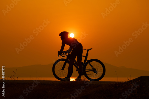 Fototapeta Naklejka Na Ścianę i Meble -  silhouette of a cyclist on sunset, the scenery sunrise in the morning in Thailand.