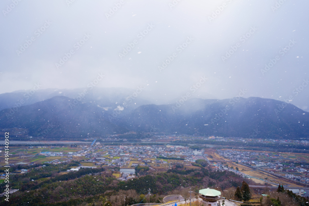 吉野川中流域に広がる平野と四国山地(徳島県三好市健康とふれあいの森からの眺望)ピントは一部の雪にのみ