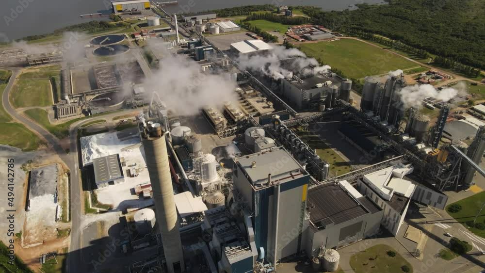 Aerial orbiting around smoking chimneys of paper mill factory, Fray Bentos in Uruguay