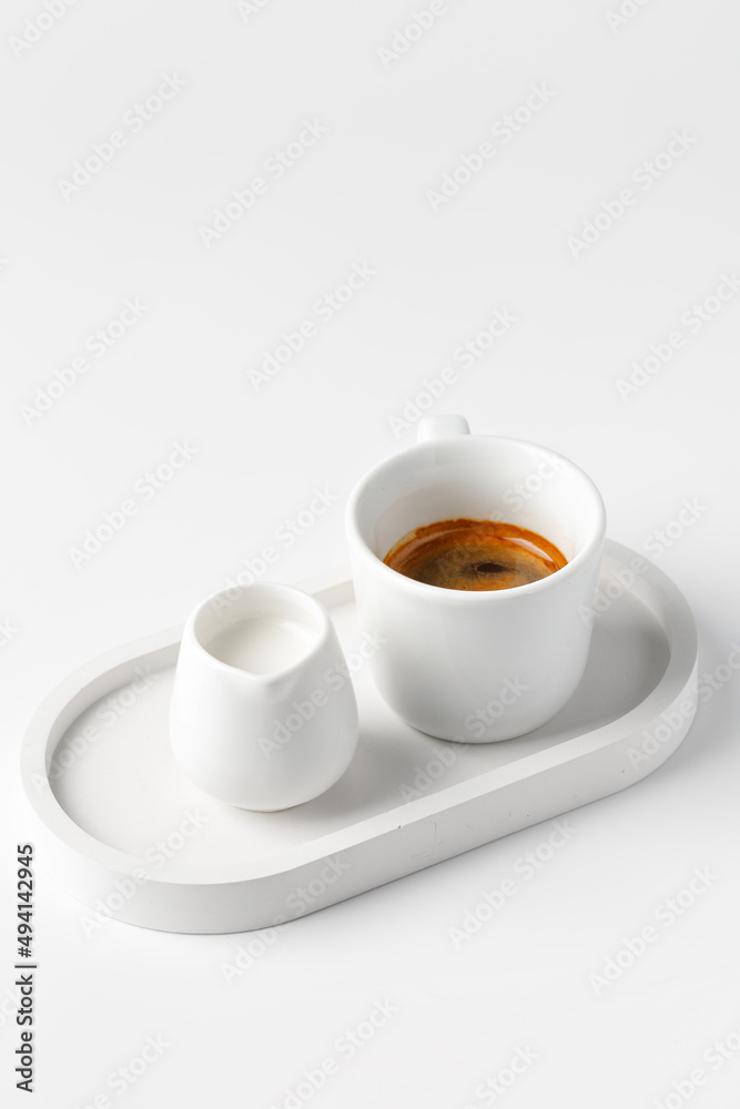 One coffee cup with espresso in morning on white tray with milk on white table. Aroma, ristretto. Mug of coffee. Close up. Breakfast One coffee cup with espresso in morning on white tray with milk on white table. Aroma, ristretto. Mug of coffee. Close up. Breakfast