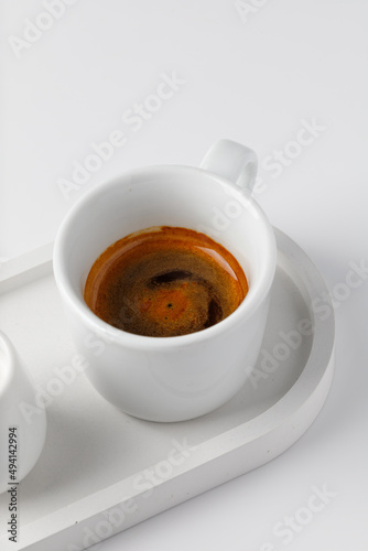 One cup with espresso or cappuccino on beton tray. Aroma, ristretto. Mug of coffee. White background. Modern. Close up