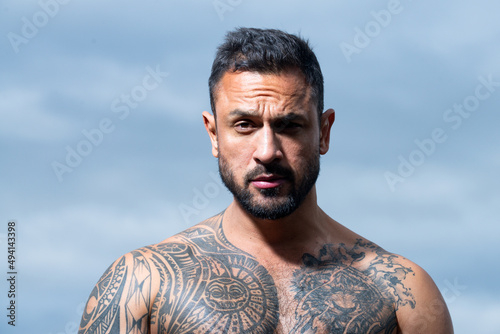 Brutal man, serious face of handsome male model, concept of men power and strong. Close up portrait of guy with serious profile face on sky. © Volodymyr