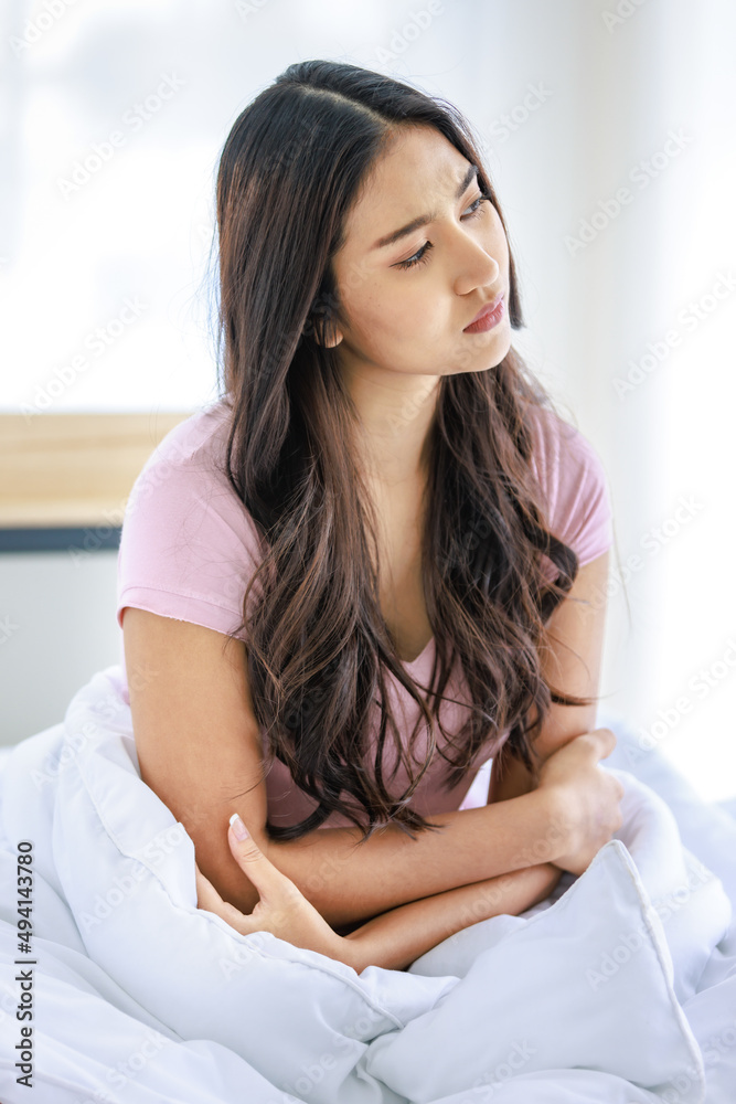 Asian young stressed depressed thoughtful lonely sadness female model in casual outfit waking up in morning sitting crossed arms alone under white blanket on bed in bedroom having depression symptom Asian young stressed depressed thoughtful lonely sadness female model in casual outfit waking up in morning sitting crossed arms alone under white blanket on bed in bedroom having depression symptom