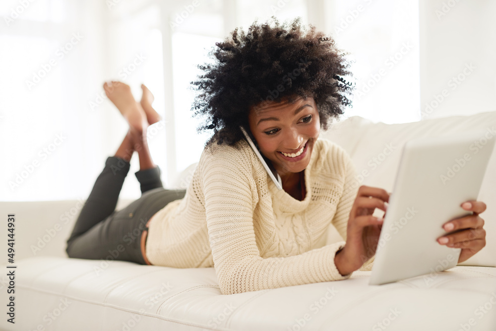Im just about to read your blog. Shot of an attractive young using her cellphone and tablet while lying on the sofa at home. Im just about to read your blog. Shot of an attractive young using her cellphone and tablet while lying on the sofa at home.