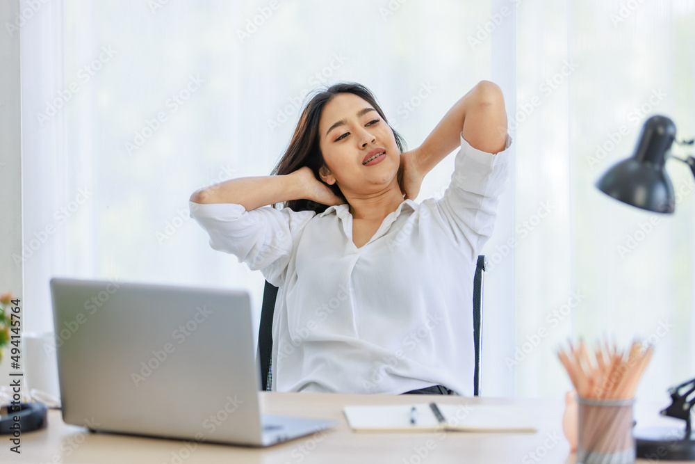 Obraz premium Asian young beautiful professional successful smart female businesswoman working with data information on laptop computer writing note on notebook at workstation desk.