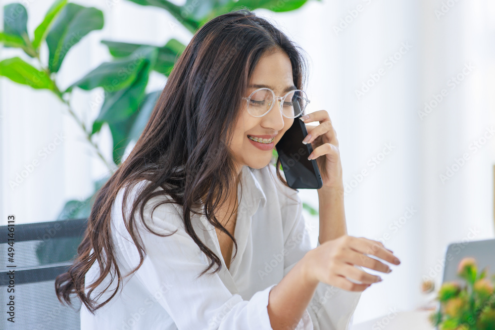 Asian young beautiful female university student wearing optical eyeglasses sitting at working desk remotely studying learning streaming online via laptop notebook computer at home during quarantine Asian young beautiful female university student wearing optical eyeglasses sitting at working desk remotely studying learning streaming online via laptop notebook computer at home during quarantine