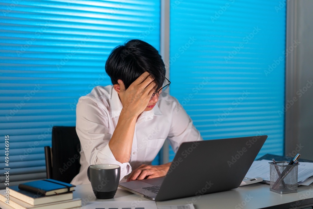 Overwork Concept The man sitting at his desk, taking off his glasses, and holding his head while working Overwork Concept The man sitting at his desk, taking off his glasses, and holding his head while working