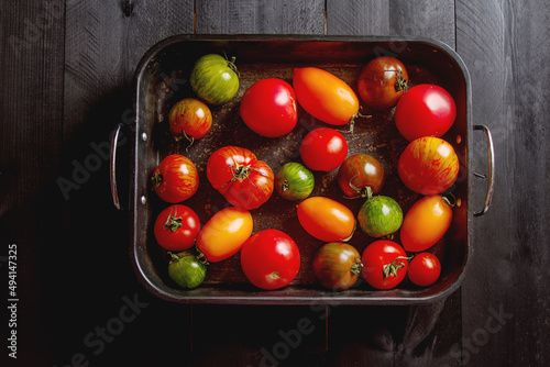 Colorful ripe tomatoes. Delicious vegetarian food. Dark background. top view