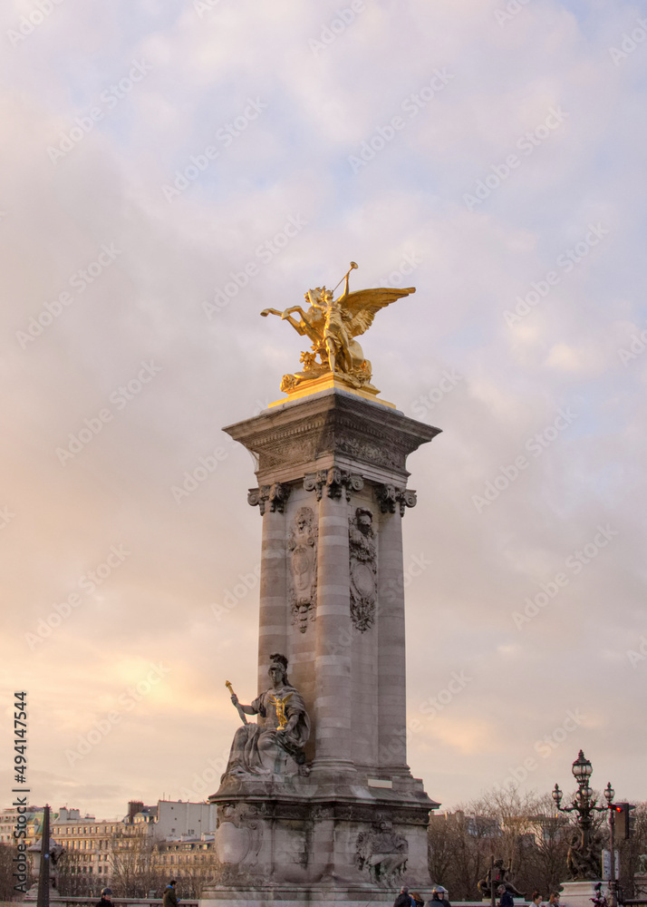 Fototapeta premium Column with a gilded pheme sculpture of Pont Alexandre III at sunset in Paris, France