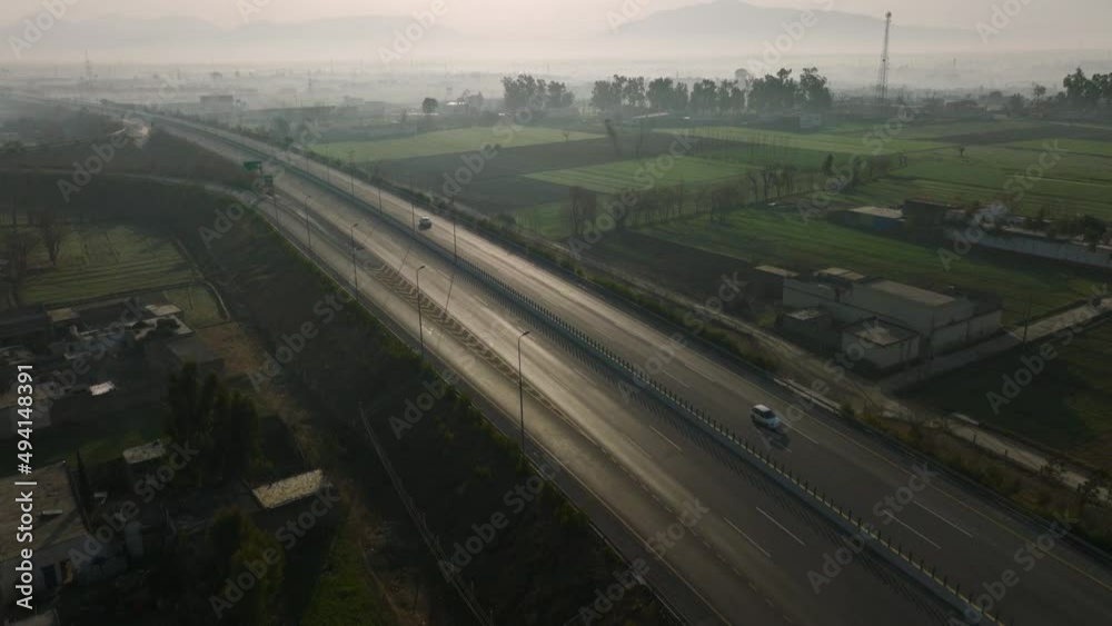 Aerial Over Hazara M 15 Motorway Through Rural Misty Landscape In Abbottabad. Dolly Back Aerial Over Hazara M 15 Motorway Through Rural Misty Landscape In Abbottabad. Dolly Back