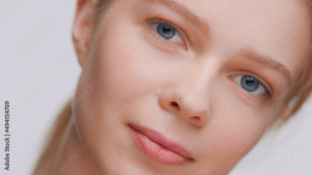 Extreme close-up beauty portrait of young pretty woman with blue eyes who looks at the camera Extreme close-up beauty portrait of young pretty woman with blue eyes who looks at the camera