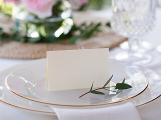 Mockup white blank space card, for Name place, Folded, greeting, invitation on wedding table setting background. with clipping path