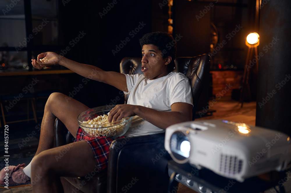 Obraz premium Surprised indignant man watching film on projector