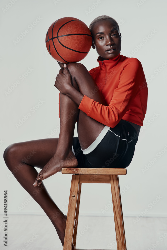 Fototapeta premium Lets meet up at the court. Studio shot of an attractive young woman playing basketball against a grey background.