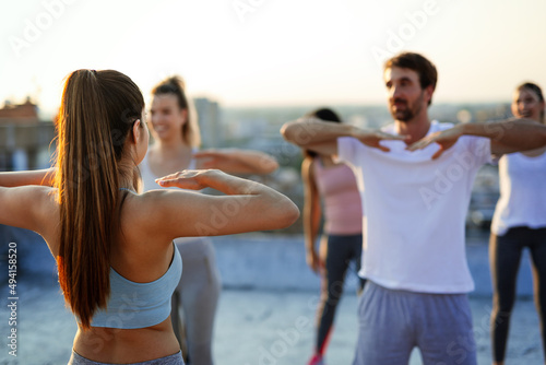 Group of happy fit friends exercising together outdoors. Sport people healthy lifestyle concept