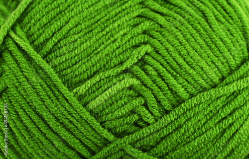 Green knitting wool close-up.Green yarn clew close up texture. Blue wool background.