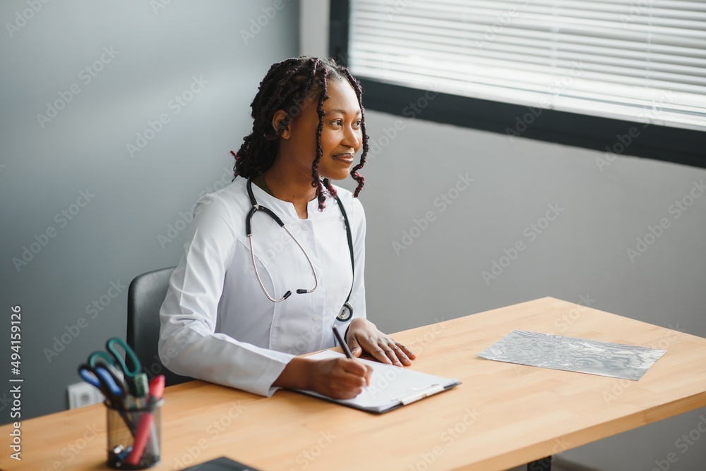 Portrait Of Female Doctor Wearing White Coat In Office