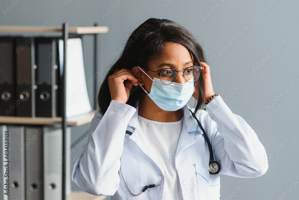 medicine, profession and healthcare concept - close up of african female doctor or scientist in protective facial mask. medicine, profession and healthcare concept - close up of african female doctor or scientist in protective facial mask.