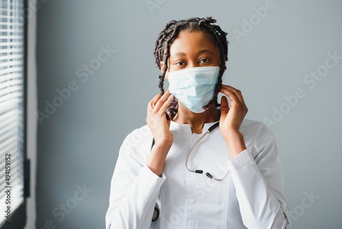 medicine, profession and healthcare concept - close up of african female doctor or scientist in protective facial mask.