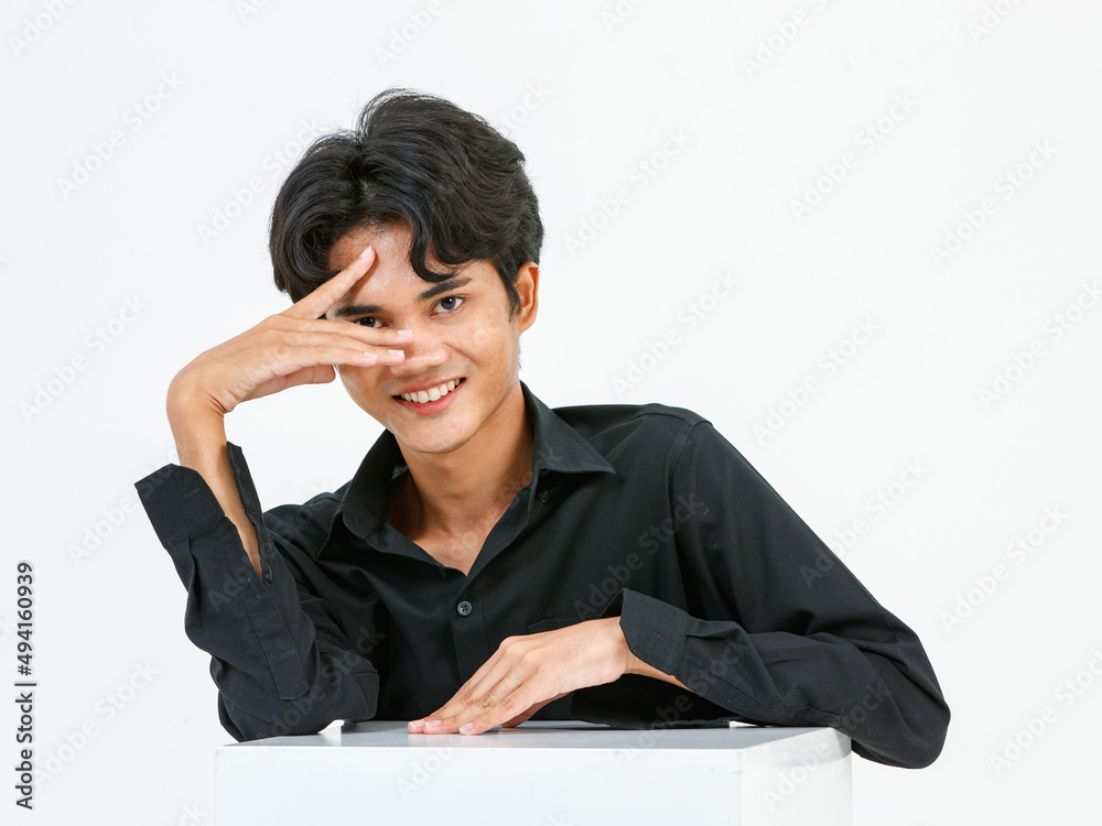 Portrait isolated cutout closeup studio shot of Asian young LGBTQ gay glamour handsome male model in casual black shirt sitting posing gesturing with square box look at camera on white background Portrait isolated cutout closeup studio shot of Asian young LGBTQ gay glamour handsome male model in casual black shirt sitting posing gesturing with square box look at camera on white background