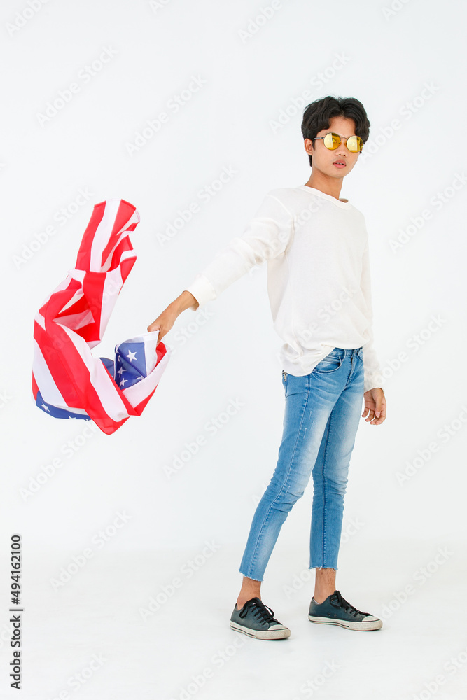 Portrait studio shot of Asian young LGBT gay bisexual homosexual male fashionable model in casual outfit and fashion sunglasses standing holding waving flying USA national flag on white background Portrait studio shot of Asian young LGBT gay bisexual homosexual male fashionable model in casual outfit and fashion sunglasses standing holding waving flying USA national flag on white background