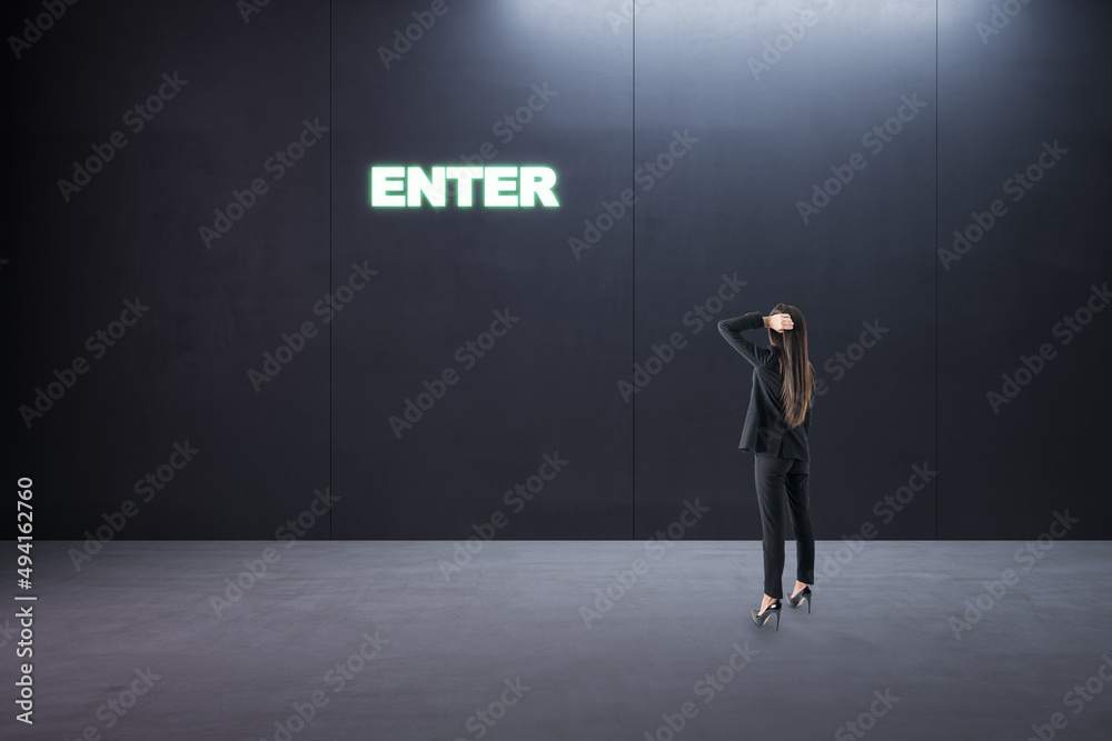 Obraz premium Thoughtful young businesswoman standing in concrete interior with entrance to success. Way and opportunity concept.