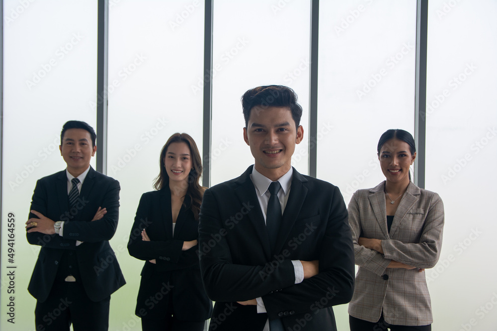Successful businessman with crossed arms standing proudly in front his business team and looking at the camera. Successful businessman with crossed arms standing proudly in front his business team and looking at the camera.