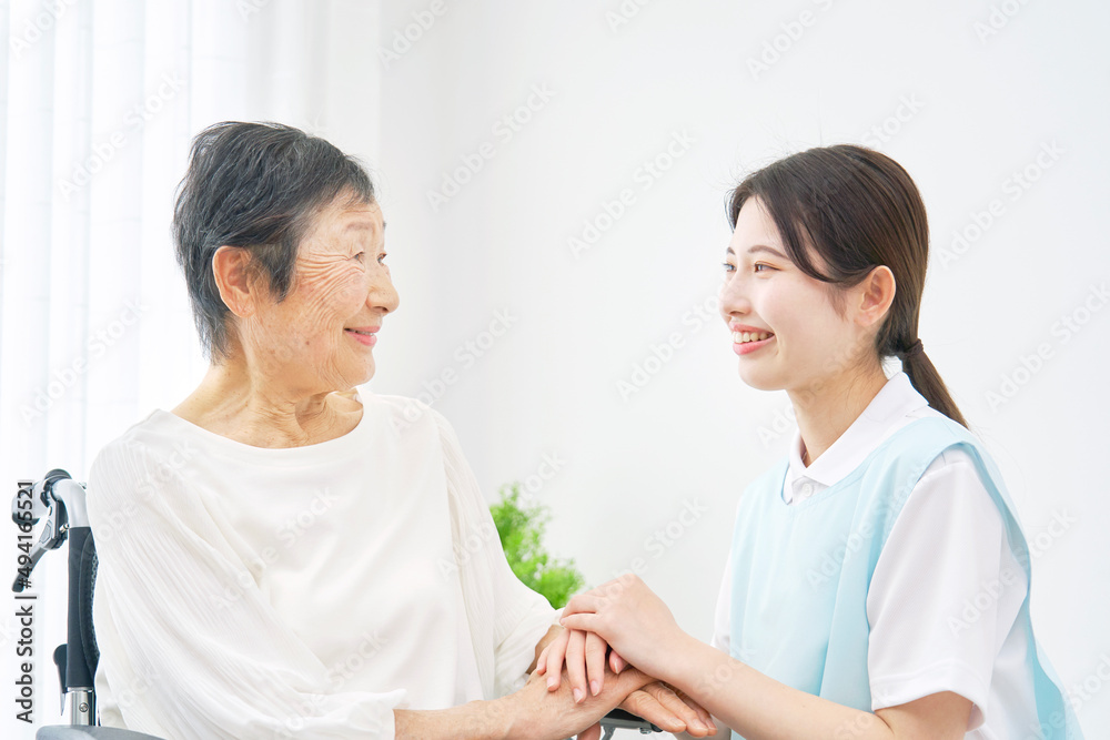 Obraz premium 介護士と車椅子に乗る高齢者 室内