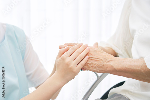 高齢者の手を握る介護士　顔無し photo