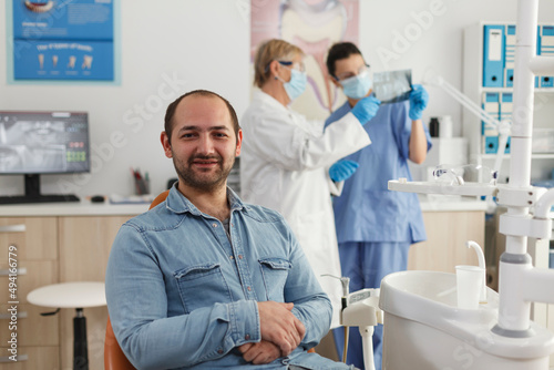 Portrait of man patient with caries infection sitting on chair waiting to start medical procedure during stomatological examination in orthodontic office  Concept of medicine services